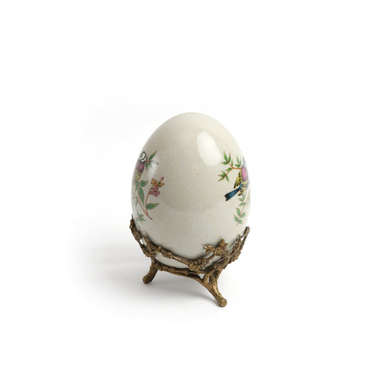 Huevo de porcelana con pájaros y base de latón